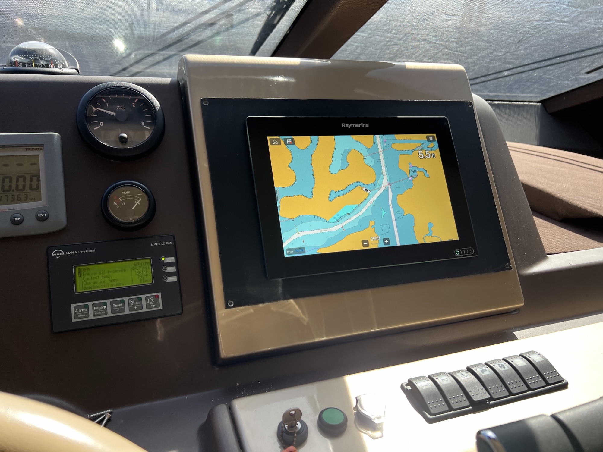 Raymarine chartplotter installed in a wood-trimmed helm